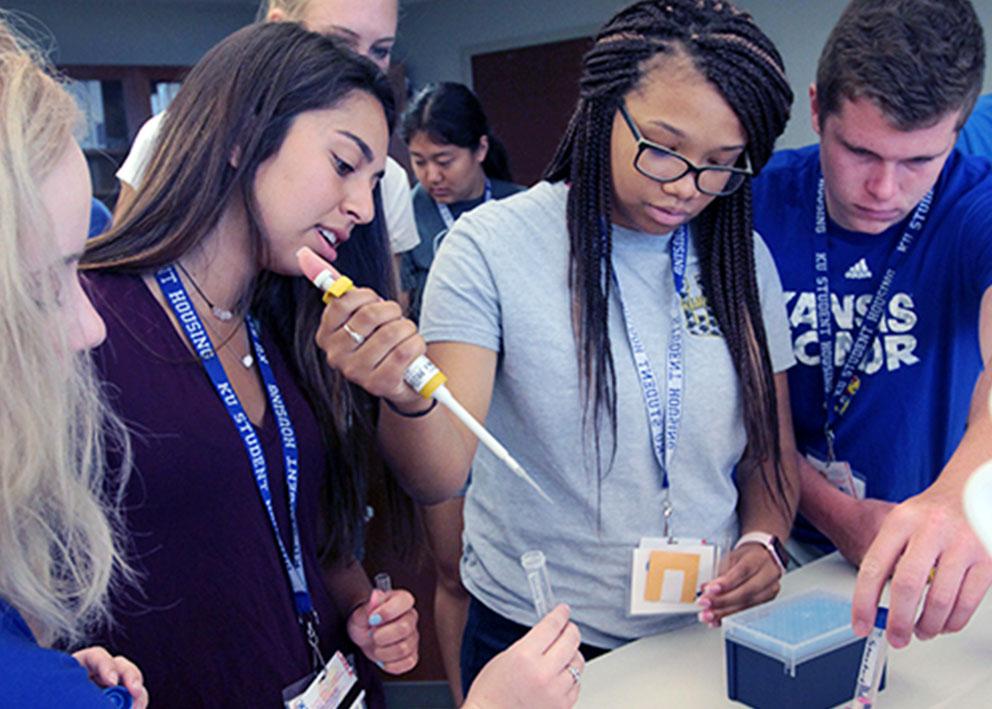 Campers gather around as counselor demonstrates pipette techniques